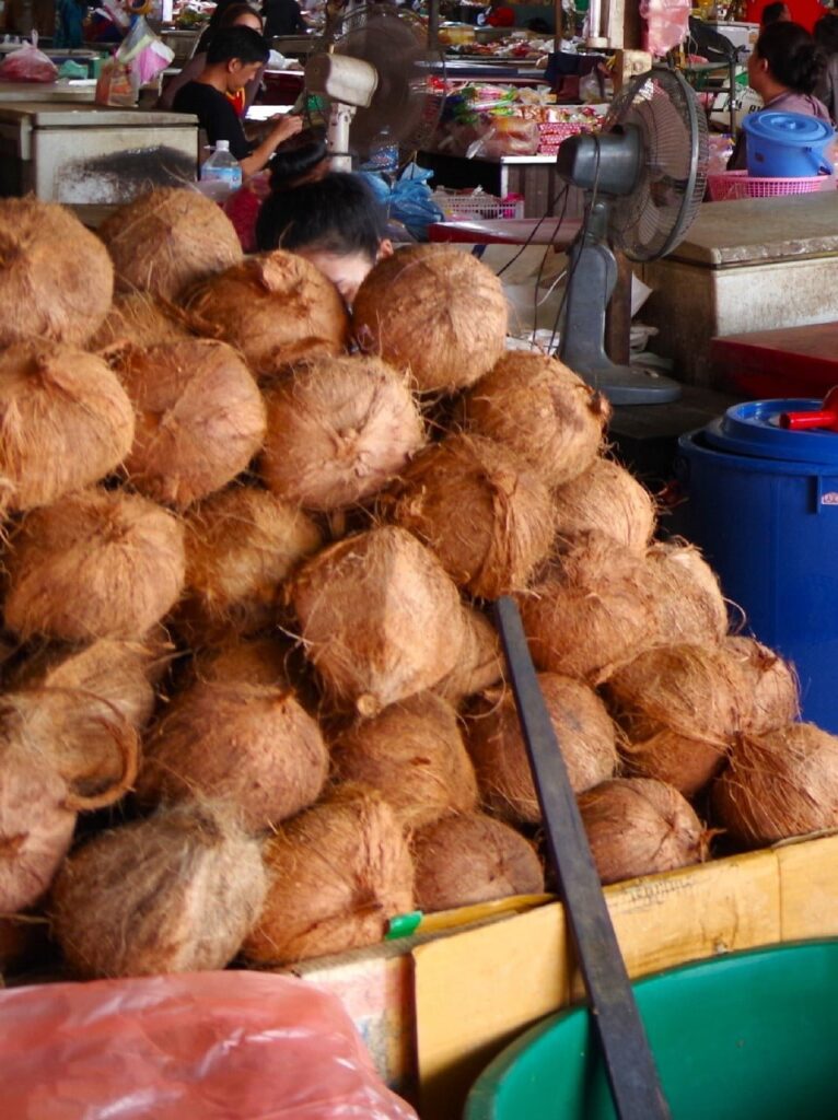 Pile de noix de coco au marché. Indispensable dans la cuisine Thaïlandaise